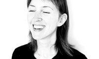 Foto av kvinne i svart-hvitt som lukker øynene og ler