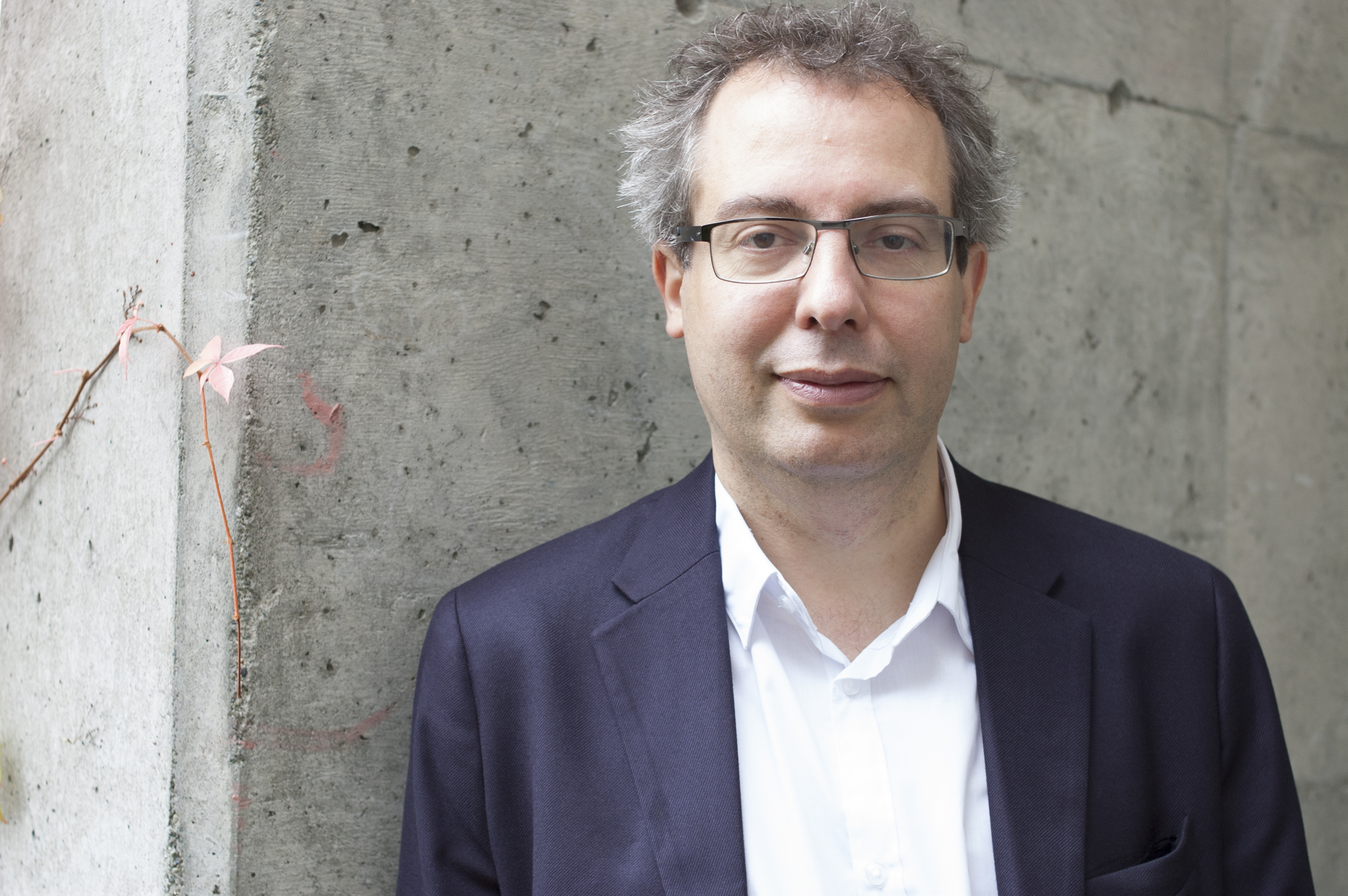 Mann i hvit skjorte og blazer ser i kameraet