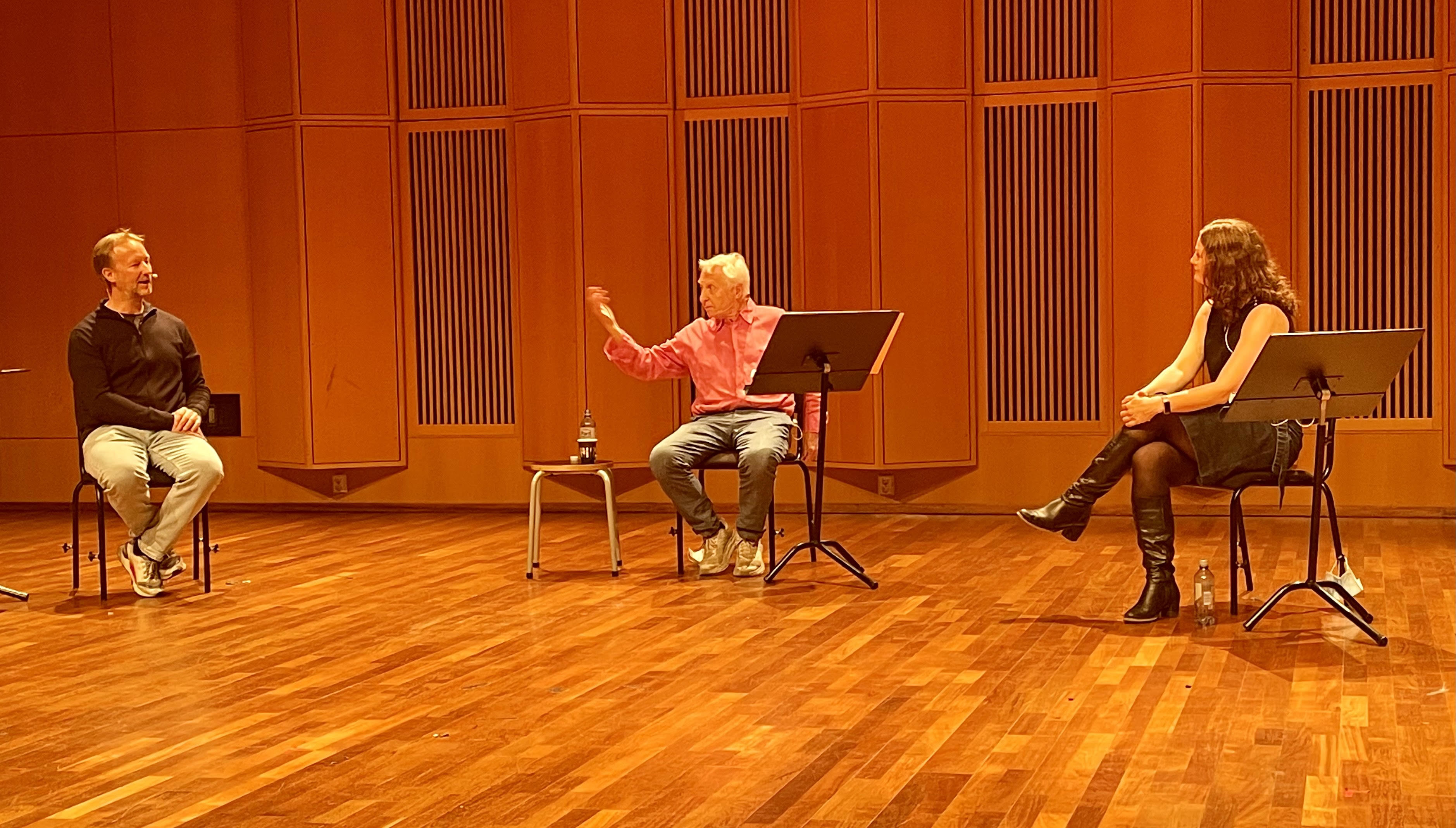 Tre mennesker sittende på stoler snakker sammen