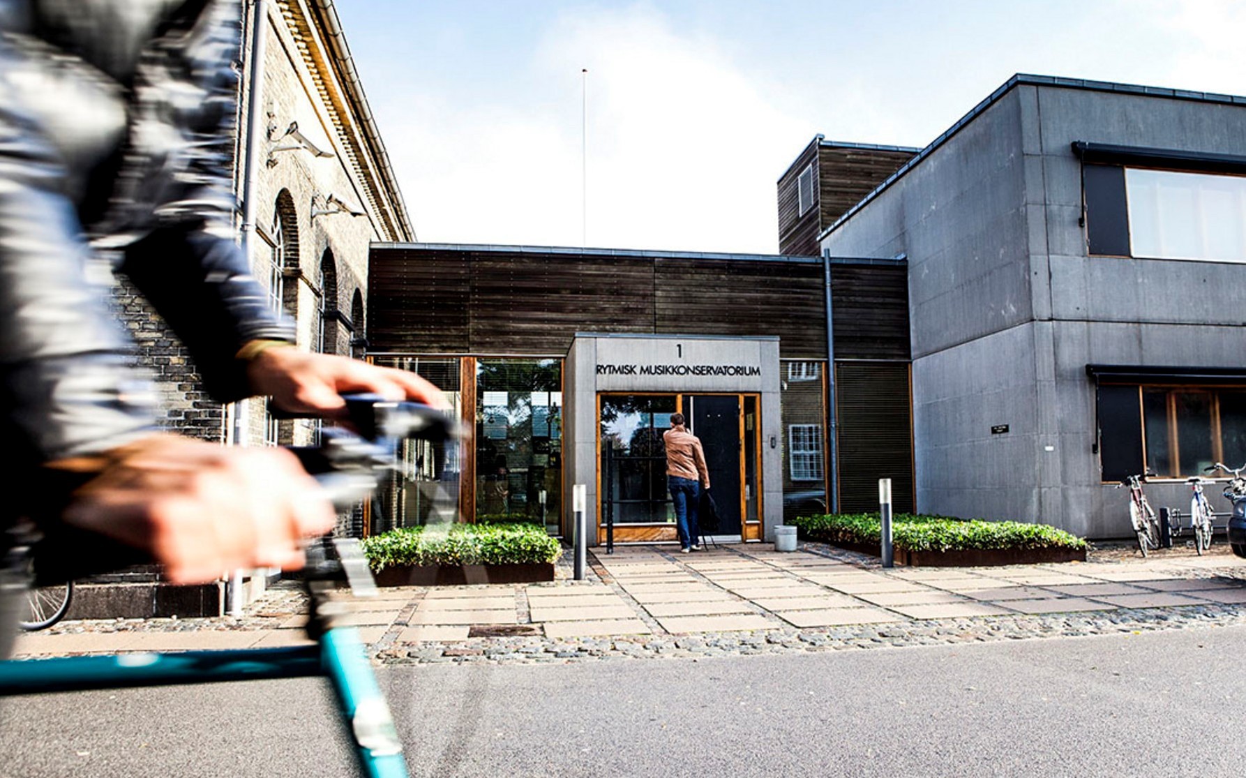 fronten av en bygning og en sykkel i fart