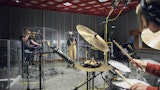 Jazzmusikere synger, spiller trompet og trommer i studio.