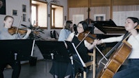 Fire studenter spiller sammen i et ensemble: En på fiolin, en på bratsj, en på cello og en spiller klaver.