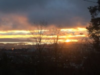 Solnedgang under mørke skyer og mørkt landskap. Novembermørke. Utsikt over Oslo fra Grefsen.