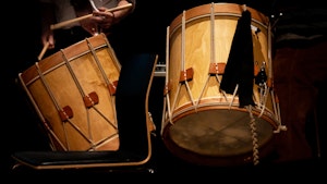 Two wooden drums. Dark background.