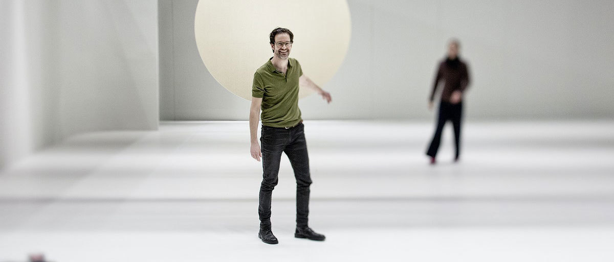 Erik Dæhlin på scenen i et hvitt rom