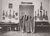 Bilde fra det gamle «museet» i Nordahl Bruns gate 8: Harper stilt opp foran dobbeltdøren ut. På veggen strengeinstrumenter.