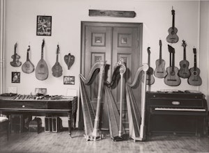 Bilde fra det gamle «museet» i Nordahl Bruns gate 8: Harper stilt opp foran dobbeltdøren ut. På veggen strengeinstrumenter.