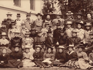 Grå-brunt klassebilde av elevene ved konservatoriet i 1898. Barn sitter foran og de voksne bak. Mange kvinner med hatter. Arkivfoto.