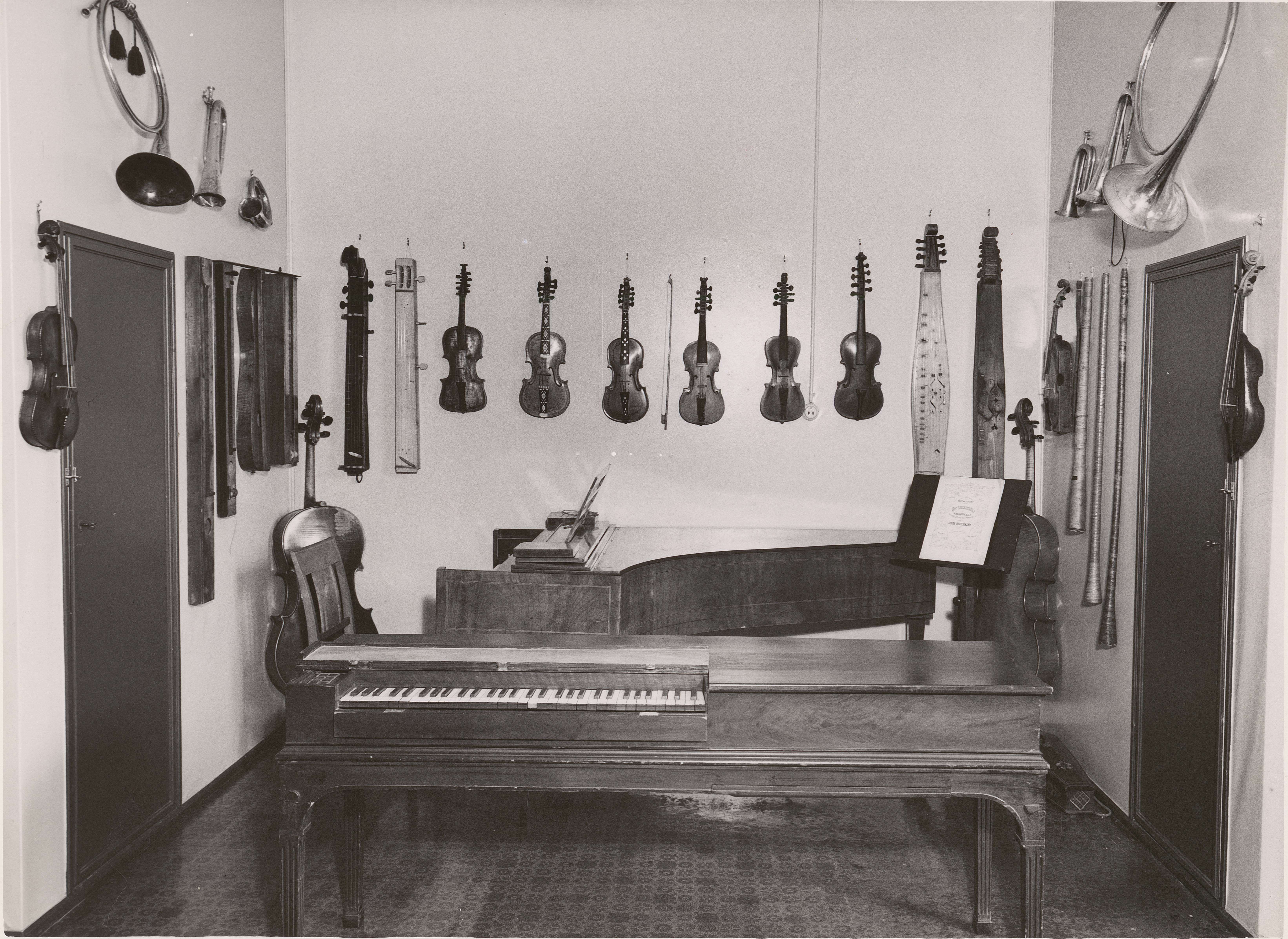 Bilde fra det gamle «museet» i Nordahl Bruns gate 8, «bakveggen»: Hardingfeler, fioliner, langeleik på veggen, cembalo og klavichord foran.