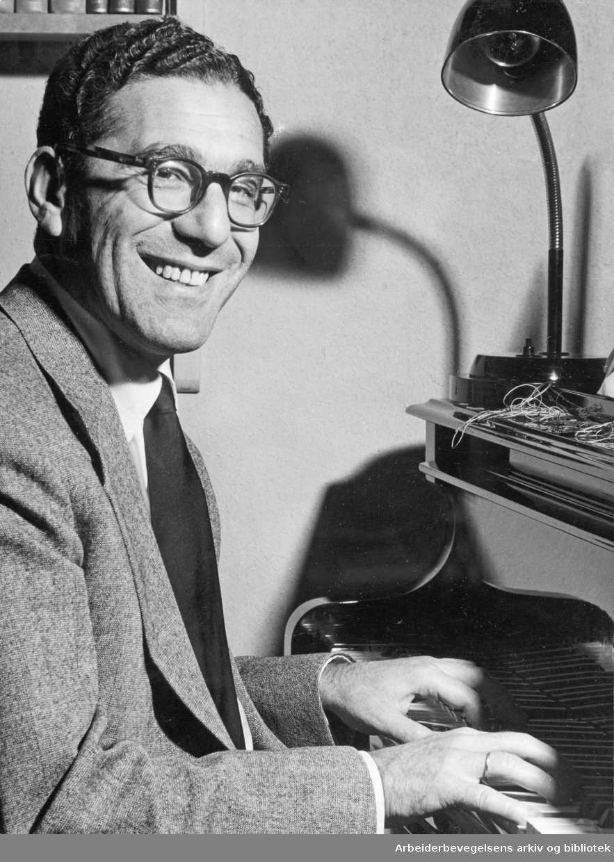 Svarthvittbilde av Robert Levin som sitter ved klaveret og smiler.