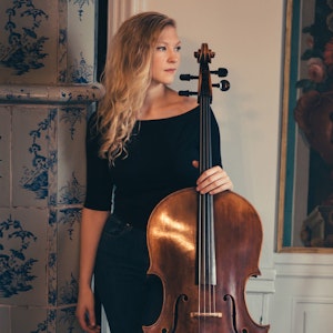 Amalie Stalheim står på stue med celloen sin