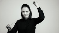 Svarthvittbilde av Eline Storheim som dirigerer, med pinne i høyre hånd.