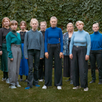 Gruppebilde av Ensemble GAEA som står i hage med klær i blånyanser.