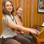Victoria Ulriksen og Maria Bue Kessel sitter ved hammerklaveret og spiller.