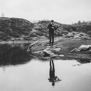 Henrik Nordtun Gjertsen spiller fele ved en innsjø