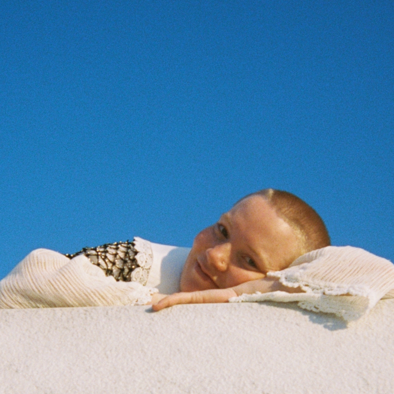 Hilja Løvvik ligger og lener seg på hendene foran knallblå himmel.