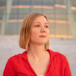 Portrett av Ingrid Hjerpset i rød skjorte.