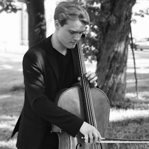 Iver Bunkholt står ute i en park og spiller på celloen sin, i svart-hvitt.