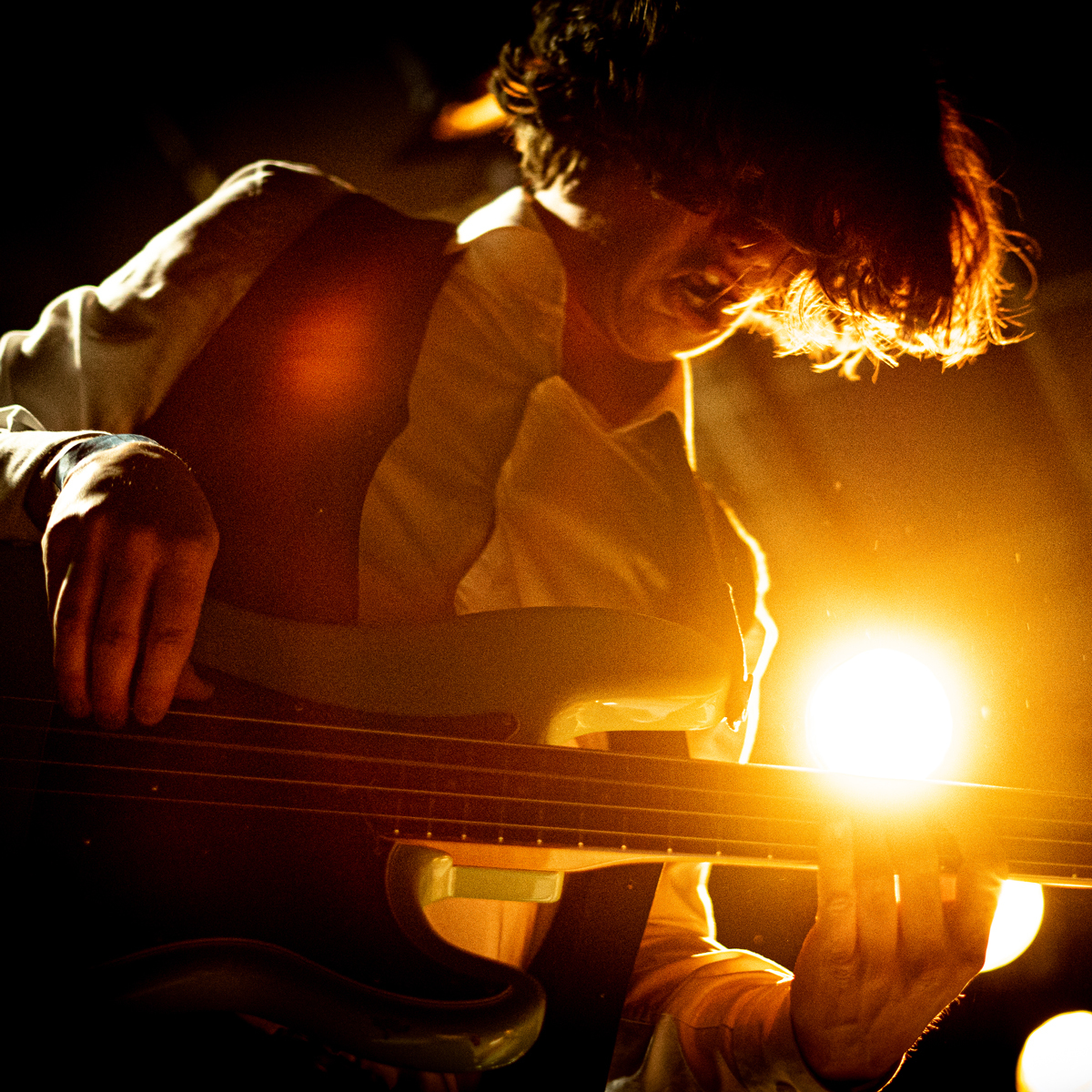 Jonas Thrana Jensen spiller med sterk lyskaster i bakgrunnen.