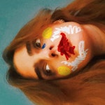 SIdelengs bilde av Larissa Terescenko med sterke påtegnede farger på kinnene i munnen.