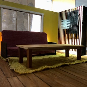 Minimalistisk foto av stue, med sofa, teppe og sofabord, med gulaktige fargenyanser
