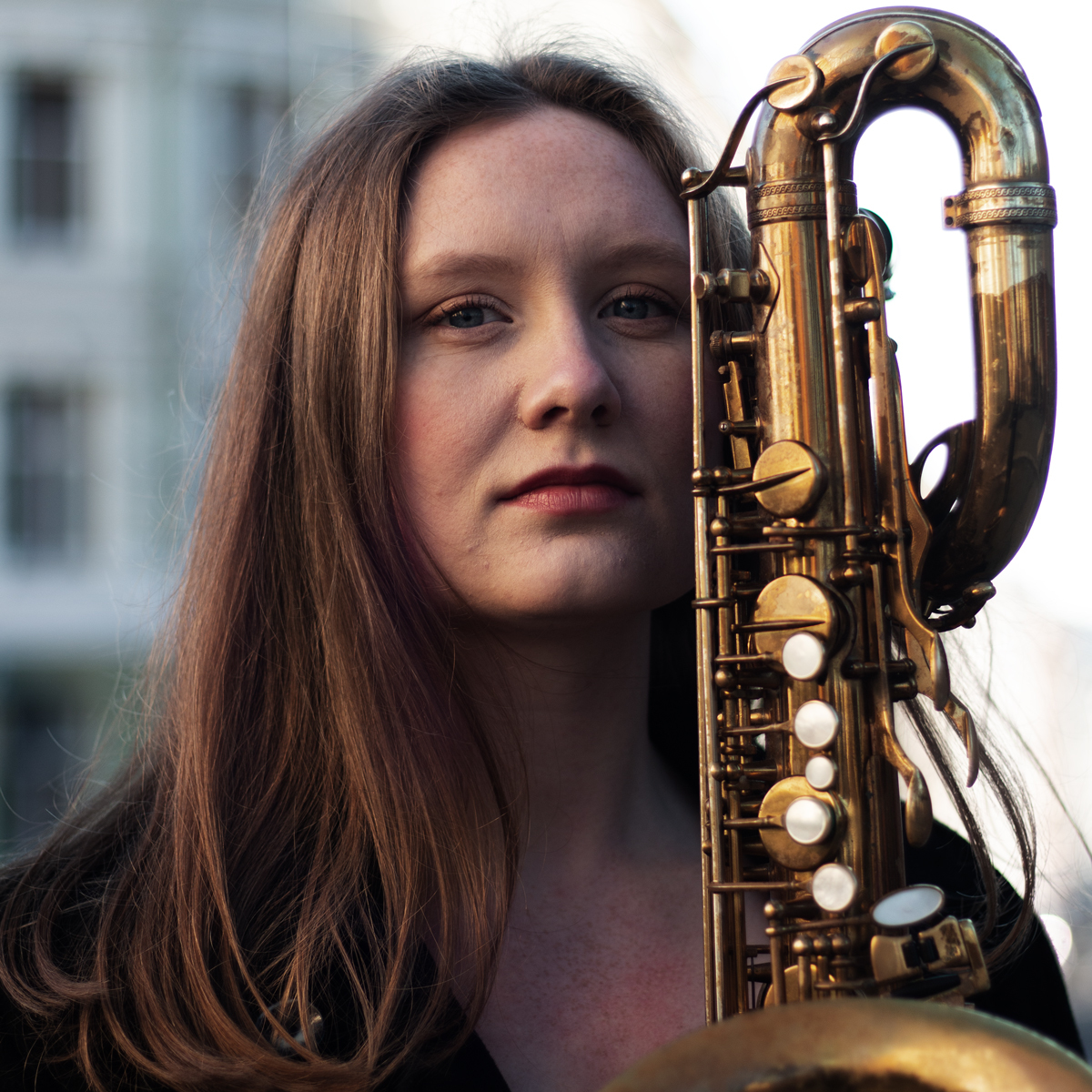 Maja Källström med saksofonen ved siden av hodet.