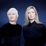 Live Maria Roggen og Ingfrid Breie Nyhus står i svarte klær foran blå vegg.