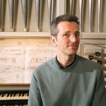Wolfgang Kogert sitter foran orgelet i grønn genser.
