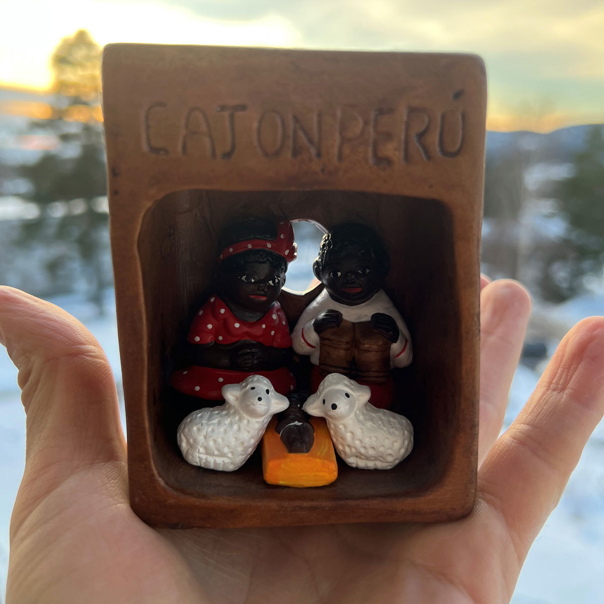 Liten julekrybbe med teksten "Cajon Peru" i hånden til noen.