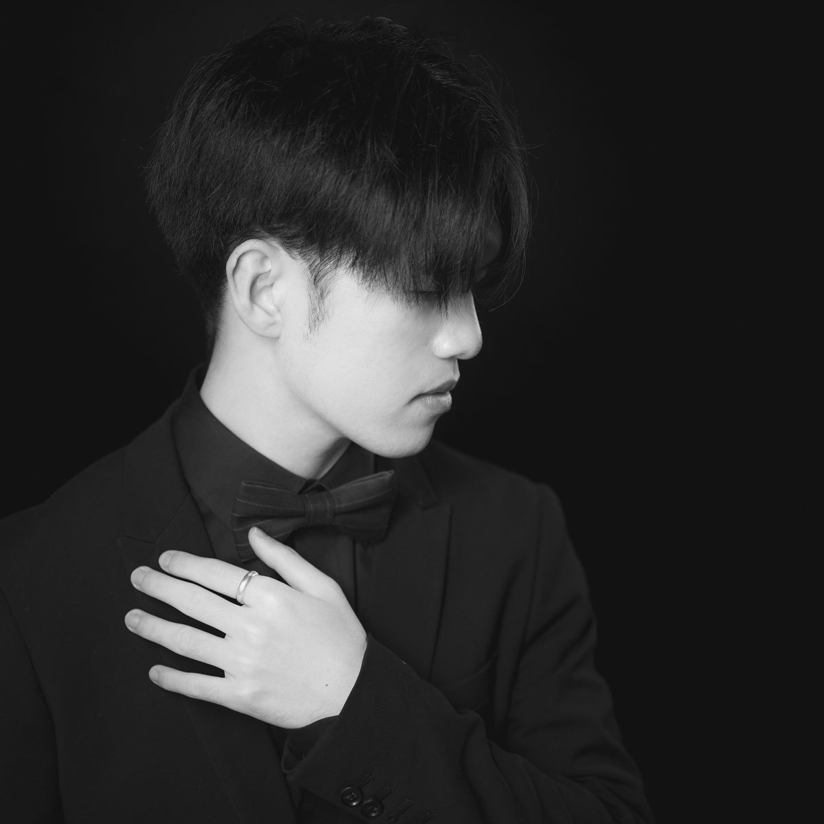 Portrett av Dacheng Li som ser til siden og holder hånden på hjertet.