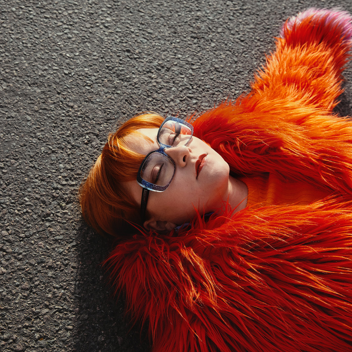 Eir Vatn Strøm ligger på bakken og lukker øynene i en stor, orange pels.