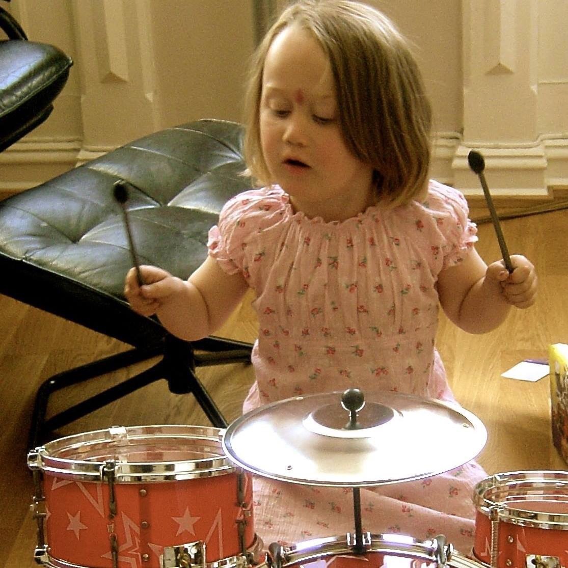 Barnebilde av Emma Østberg som spiller trommesett.