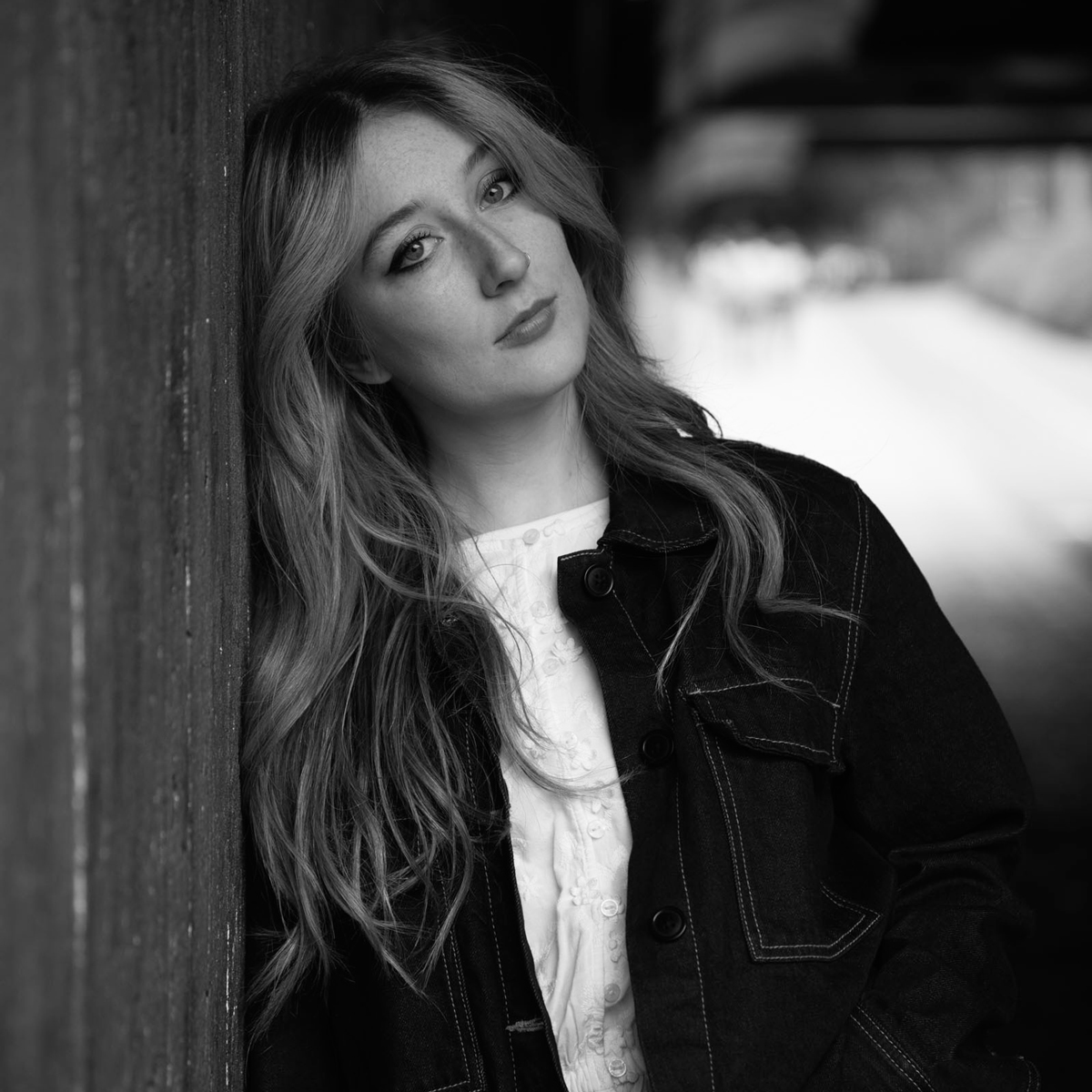 Svarthvitt-portrett av Esther Viola Nyström som lener seg mot en vegg.