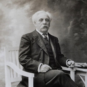 Gammelt foto av Gabriel Fauré som sitter i en stol