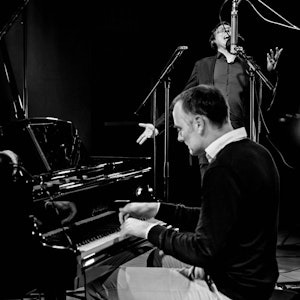 Gunnar Flagstad spiller klaver, mens Frank Havrøy står og synger i bakgrunnen.