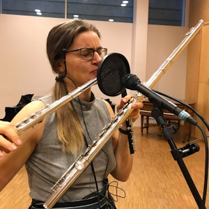 Frida Lereng spiller på to tverrfløyter foran en mikrofon med popfilter.