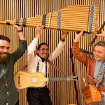 Musikerne i Gammalt er gøy står og smiler med instrumentene sine opp i lufta.