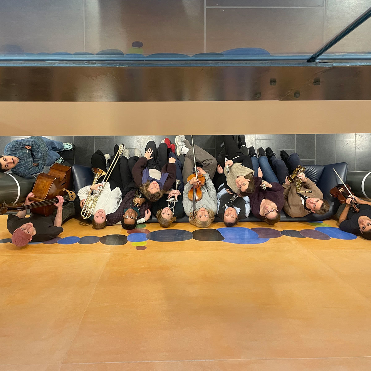 InterC-klassen står ved orange vegg og kikker opp i kameraet.