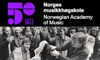 Einar Solbu og Harald Jørgensen popper en flaske champagne under feiring av at Musikkhøgskolen får eget bygg, i 1984. Bak dem står masse studenter og lærere.