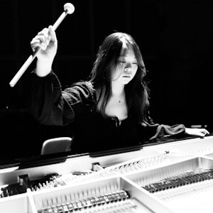 Katherine Chihchi Hsu slår på et åpent piano med en trommestikke.