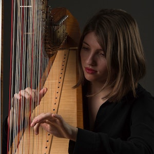 Lara Krzysko spiller harpe og ser konsentrert på harpen.