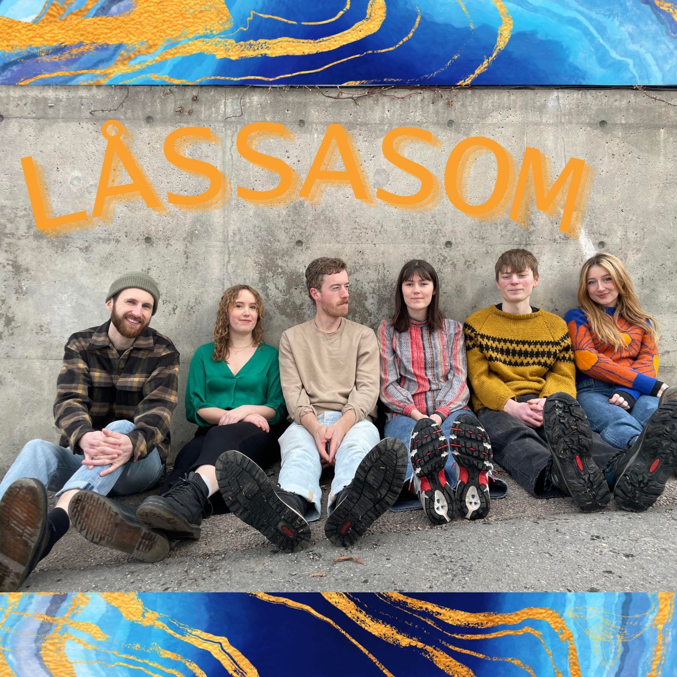 Medlemmene i bandet Låssasom sitter lent mot en betongvegg.