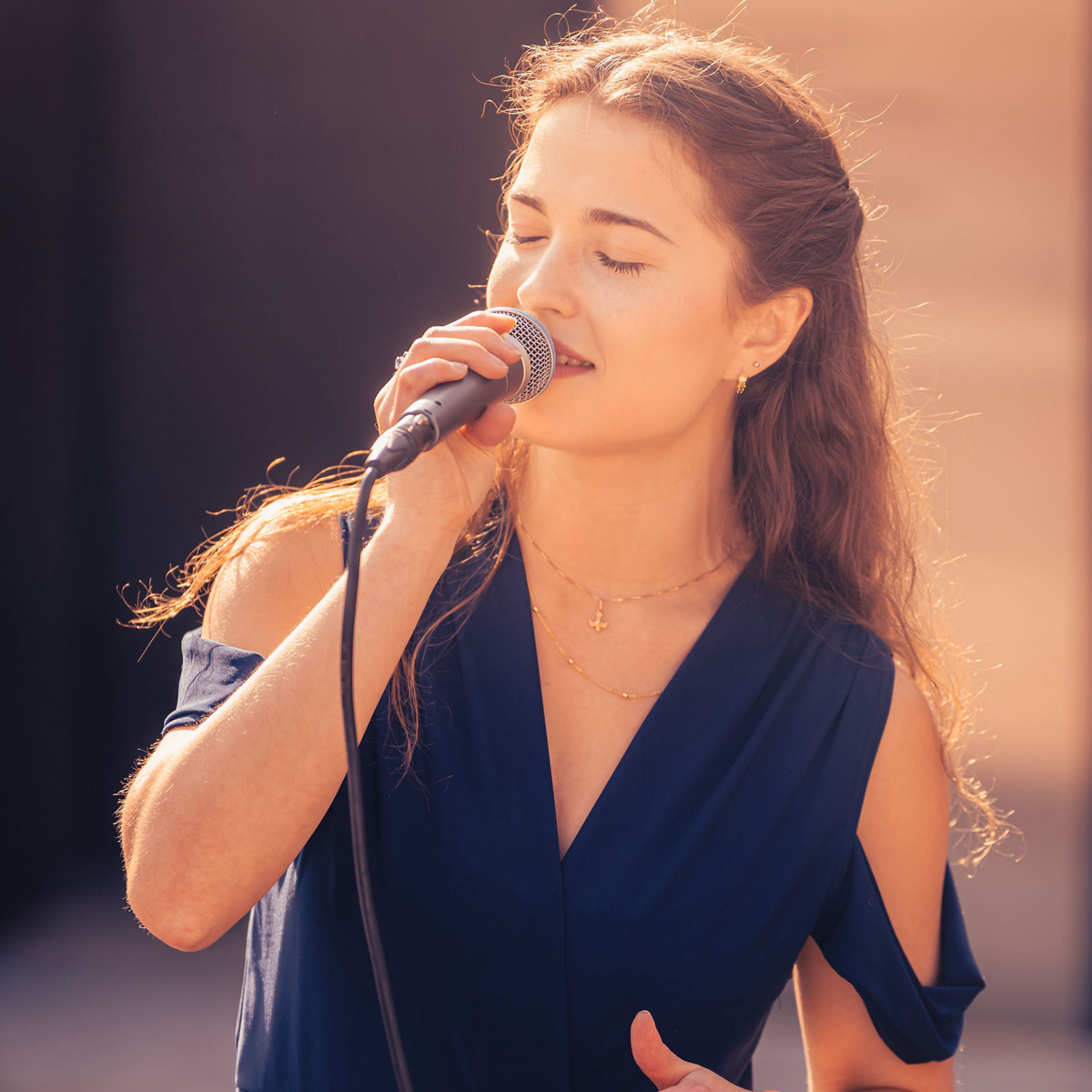 Linn Theresa McDonnell synger med mikrofon i hånden.