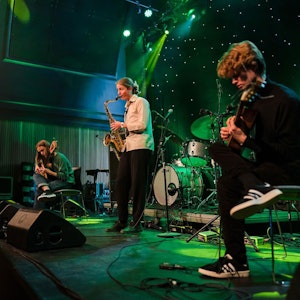 Munch trio på scenen med grønt lys.