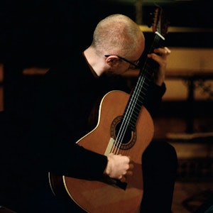 Tomas Laukvik Nannestad spiller gitar med hodet vendt bort.