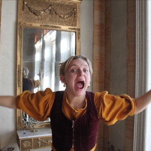 Victoria Oftestad står foran et gammelt speil, med armene ut og skriker.