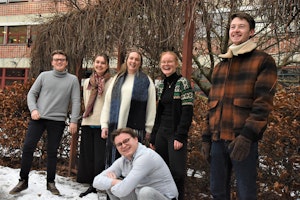 De seks studentene som utgjør SUT 2021–2022, står ute i snøen og ler.
